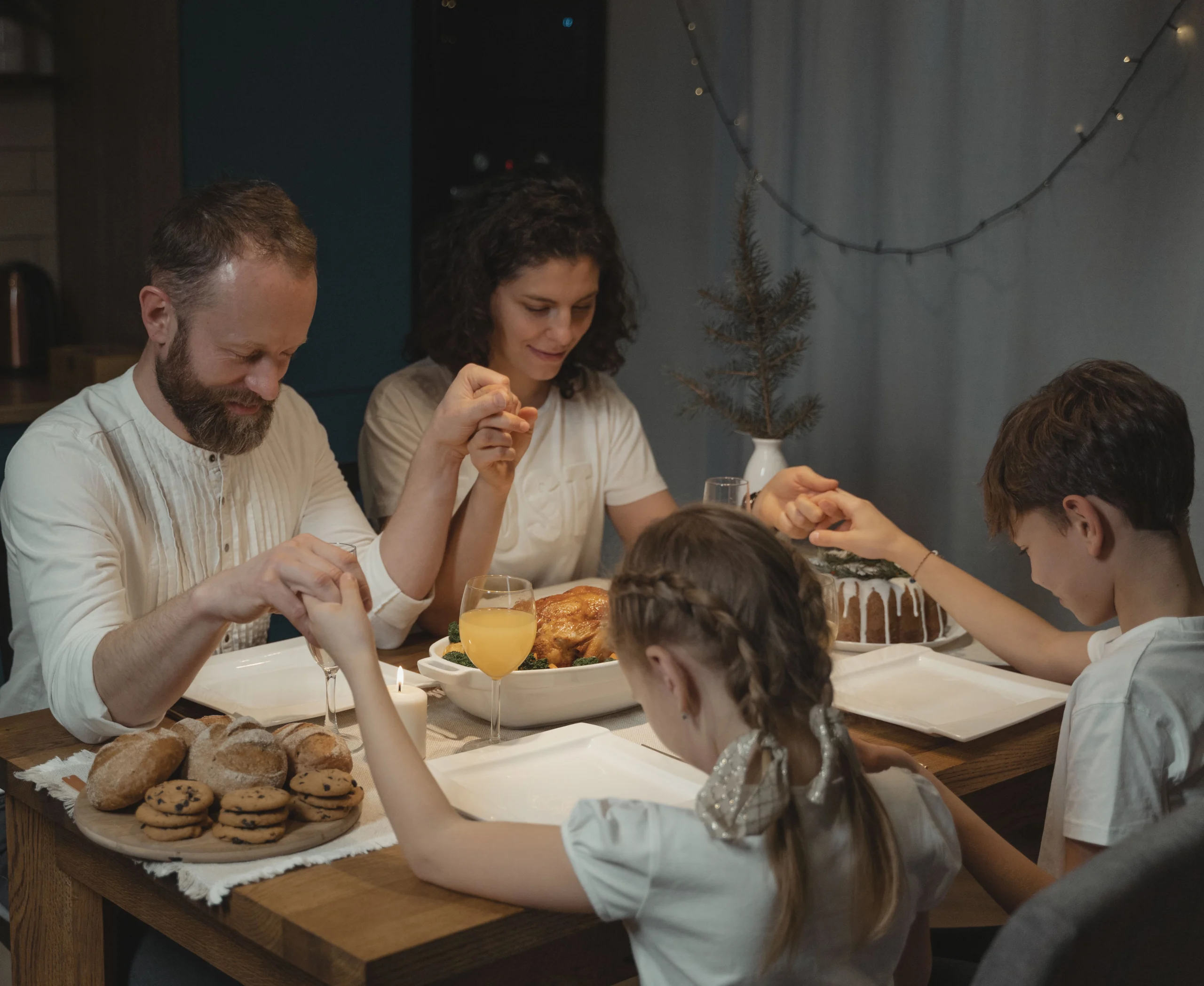 family praying together at the dinner table